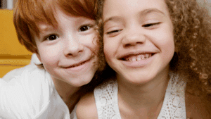 young siblings hugging and smiling